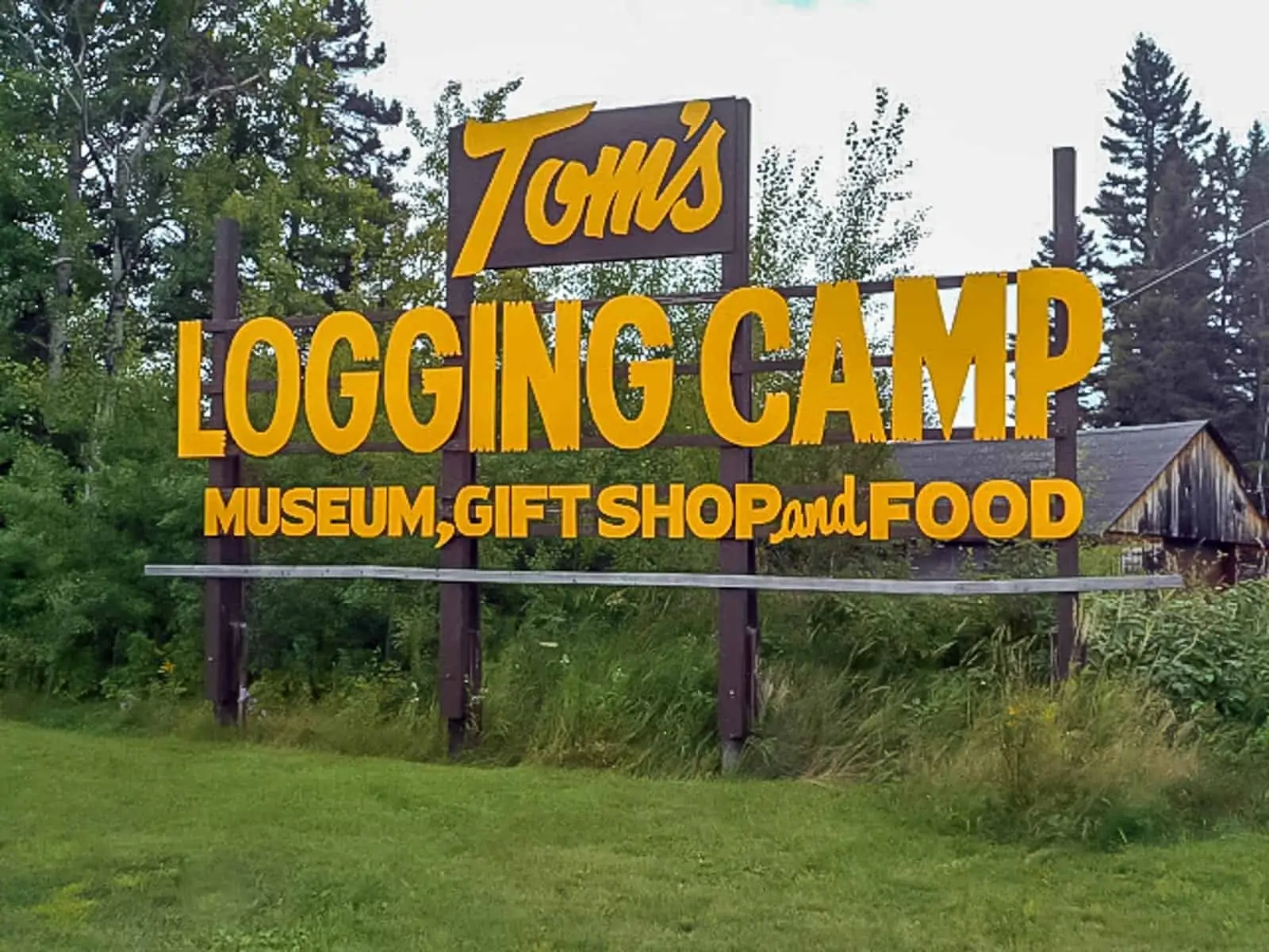 Tom's Logging Camp sign. Text: Museum, Gift Shop and Food.