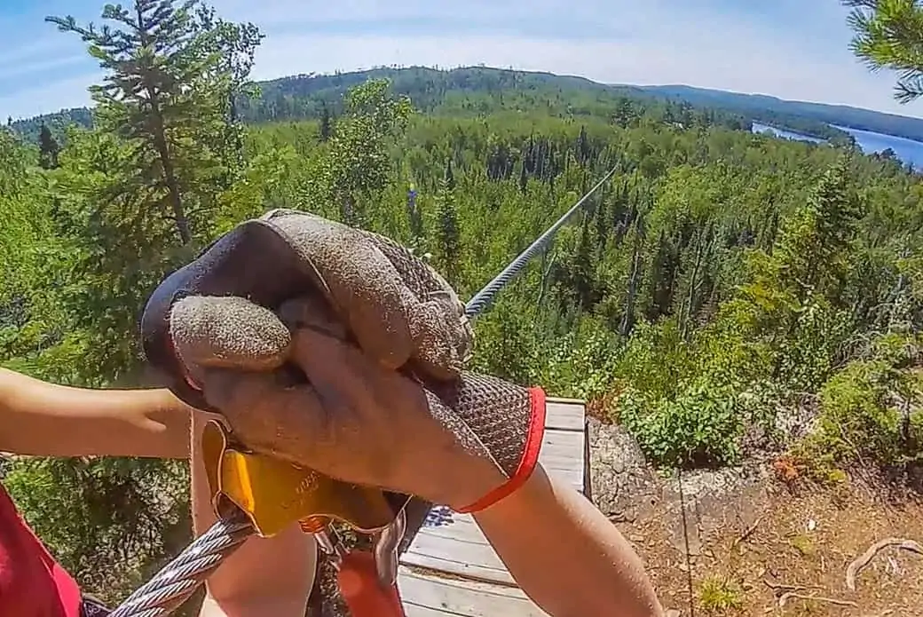 Close up of Person's gloves on a zipline.
