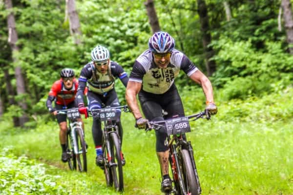 Every year, on the last Saturday of June, Lutsen plays host to a series of mountain bike races that take riders through the vast wilderness of Northern Minnesota. Cutting through dirt, mud, weeds, and maneuvering around rocks, racers start with a 1,000 foot climb up Caribou Trail and then part ways through a challenging course along miles of bike trails, snowmobile trails, Forest Service roads, and single track. This race series is known as the Lutsen 99er. The race currently offers 4 challenging courses: the 25er, the 49er, the 69er, and the 99er. Racers vary from beginners to life-long ultra-marathon racers, both young and old. They gather together at the Lutsen Mountain ski area where the race begins and ends. The Lutsen 99er is a rare event where there really is something for all levels of biker. Events include the main races on Saturday and then a free children's day on Sunday, where young riders can get a feel and start their passion for mountain bike racing. The race has also grown considerably since it's humble beginnings in 2011 when 70 racers came together to compete in the 39er and 99er races. The next year, 2012, brought 425 racers. 840 racers made their way up to the North Shore in 2013 and then the race sold out with 1200 racers in 2014. In 2015 it was expanded to allow 1600 racers. Since 2016 race participation has maxed out at 1800 racers (and it does sell out about a month in advance every year!). The growth of the Lutsen 99er has brought a much-needed boom to the North Shore Area during a time that is usually slower-paced. Ski season has ended and the summer season hasn't quite reached full swing. But now local businesses and accommodations find themselves busier than ever on the last weekend in June thanks to the racers who come up to not only enjoy the scenic ride but the many other attractions the area has to offer. Cascade Vacation Rentals is proud to serve as Race Headquarters for the Lutsen 99er events. Our office at 5335 Highway 61 in Lutsen has informational packets as well as fellow racers who are anxious to push themselves to the limits. About half of our staff participates in the race each year. If we're not on bikes, you can also see Cascade Vacation Rentals staff with cameras in hand on the course and at the finish line doing race photography. Head on over to the Lutsen 99er Official Website for more information on the best locations for spectating, view results and photos, and to register for the Lutsen 99er races. Remember that the races have sold out about a month in advance of the races in recent years! You can also follow the Lutsen 99er Facebook page for more information. Lutsen 99er Film by Drew Bentley