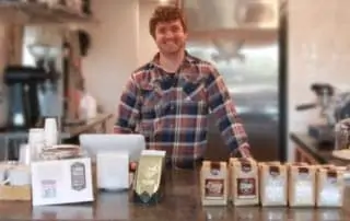 Fika Coffee counter with Barista and bagged coffee.