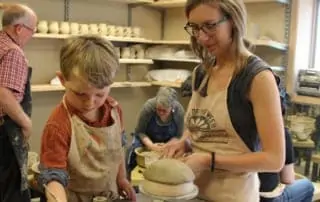 Woman and child molding clay.