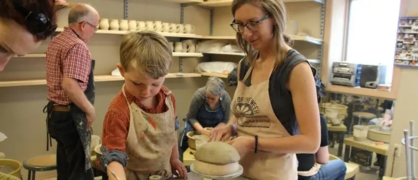 Woman and child molding clay.